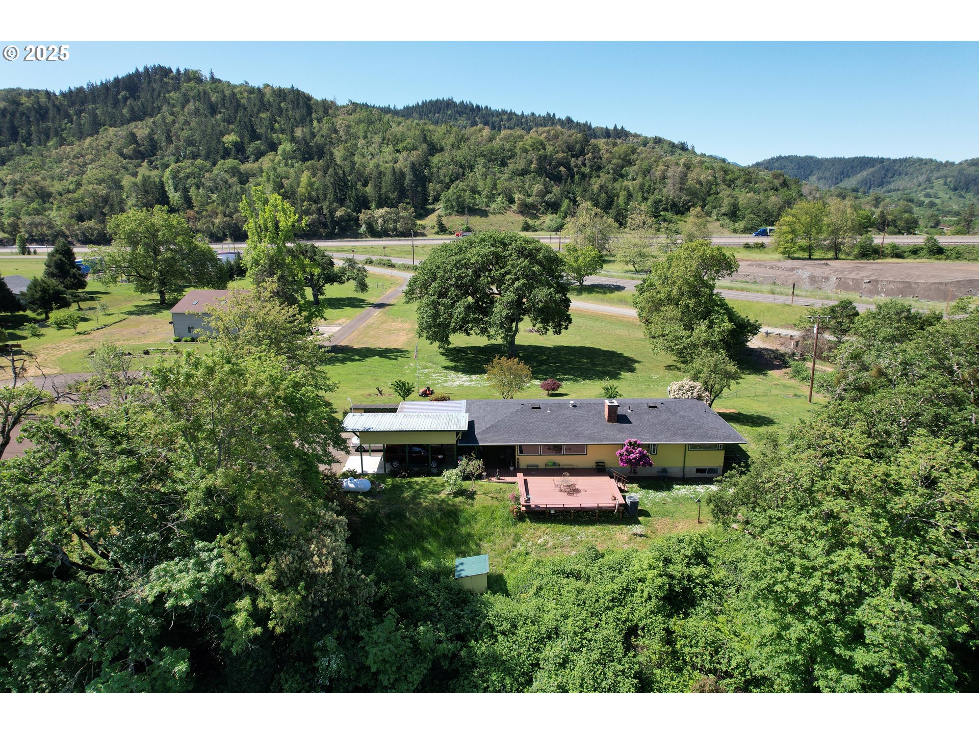 180 Ruckles Drive Myrtle Creek, OR 97457 - Photo 3 of 45 a view of a house with a mountain in the background