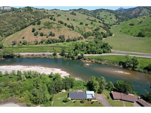 an aerial view of a house with a garden and lake view