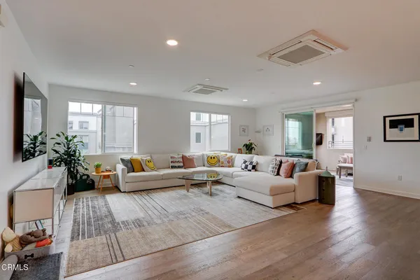 a living room with furniture and wooden floor