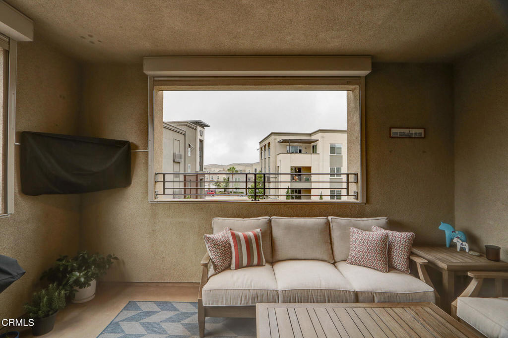 2810 Wagon Wheel Road, Unit 304 Oxnard, CA 93036 - Photo 26 of 36 a living room with furniture and a floor to ceiling window