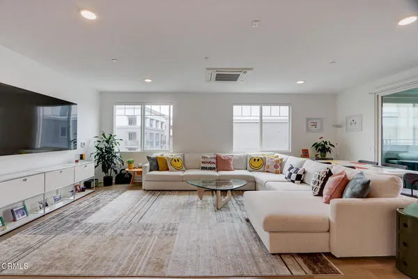 a living room with furniture flat screen tv and window