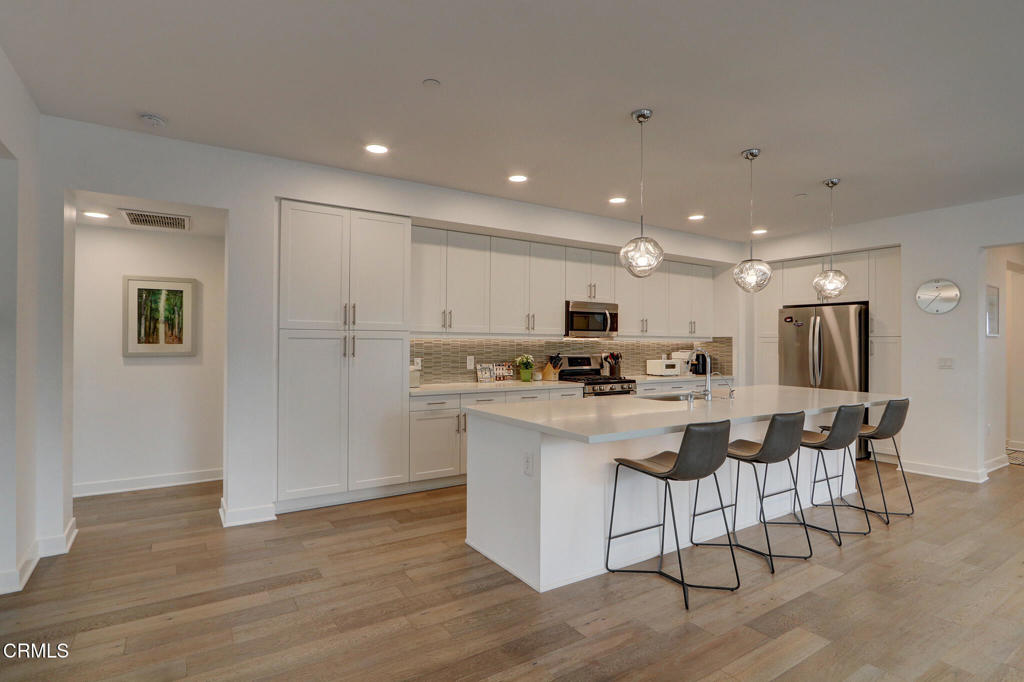 2810 Wagon Wheel Road, Unit 304 Oxnard, CA 93036 - Photo 6 of 36 a kitchen with kitchen island white cabinets and stainless steel appliances