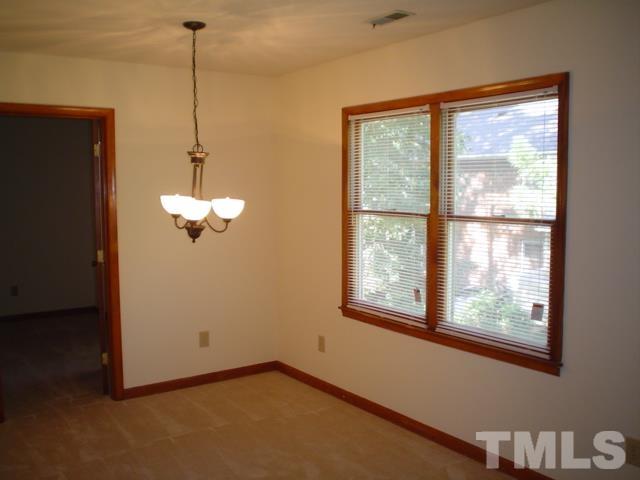 3247 Mill Run, Unit N/A Raleigh, NC 27612 - Photo 2 of 8 a view of a room with a large window chandelier furniture and windows