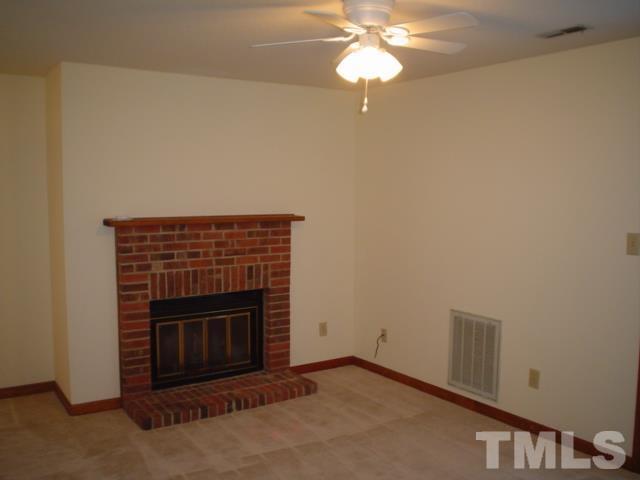 3247 Mill Run, Unit N/A Raleigh, NC 27612 - Photo 3 of 8 an empty room with a fireplace