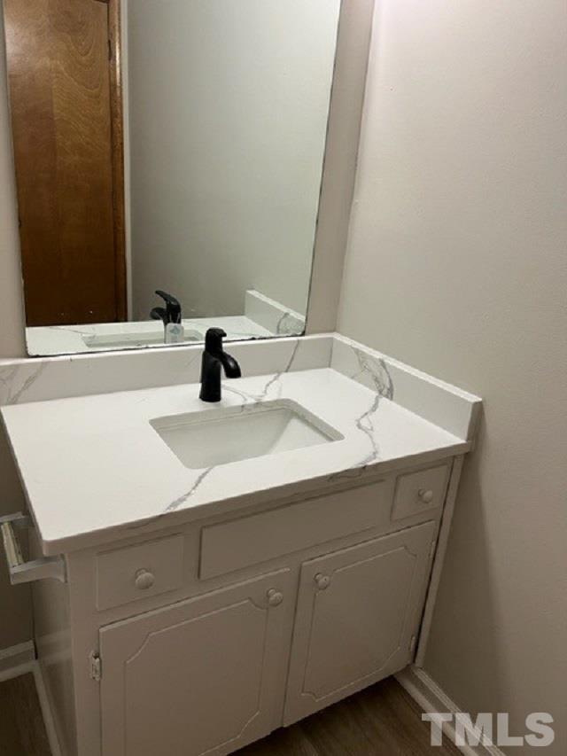 3247 Mill Run, Unit N/A Raleigh, NC 27612 - Photo 8 of 8 a bathroom with a sink and a mirror