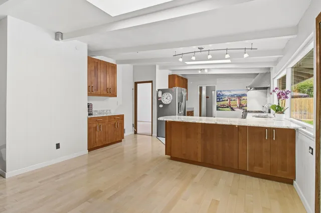 a living room with stainless steel appliances kitchen island granite countertop wooden floors and view living room