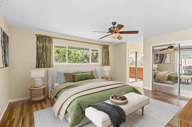 a bedroom with a bed a couch and large window