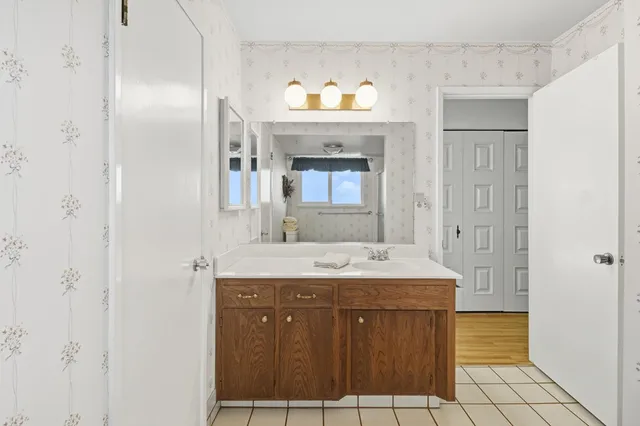 a bathroom with a granite countertop sink a mirror and a shower
