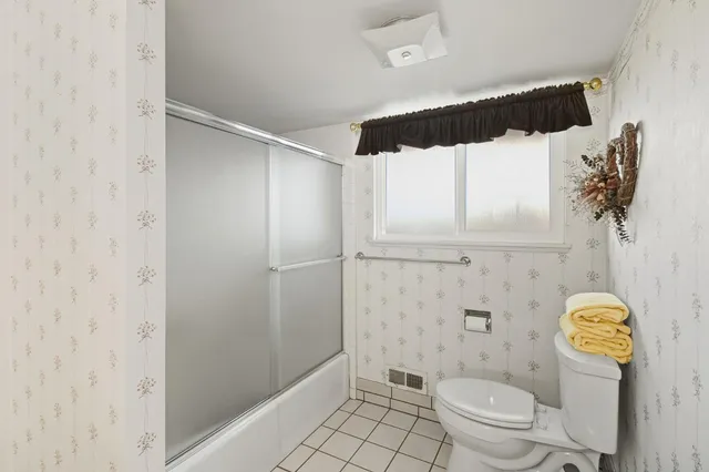 a bathroom with a toilet and a shower