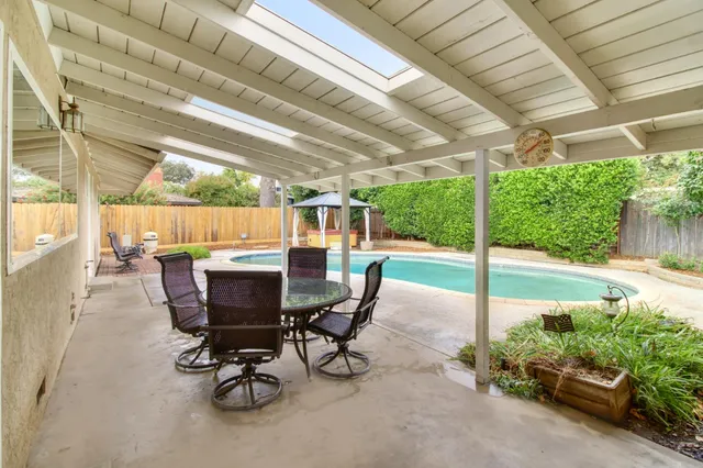 a view of a patio with table and chairs potted plants with wooden floor and fence