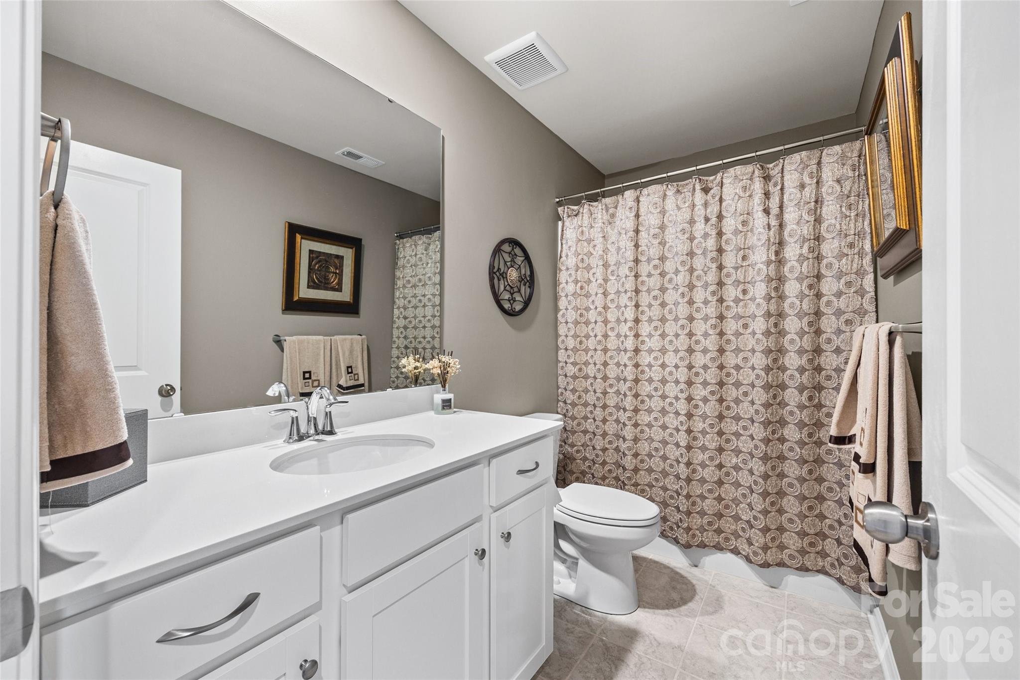909 Cobbled Way Fort Mill, SC 29715 - Photo 17 of 31 a bathroom with a sink a toilet and shower curtain