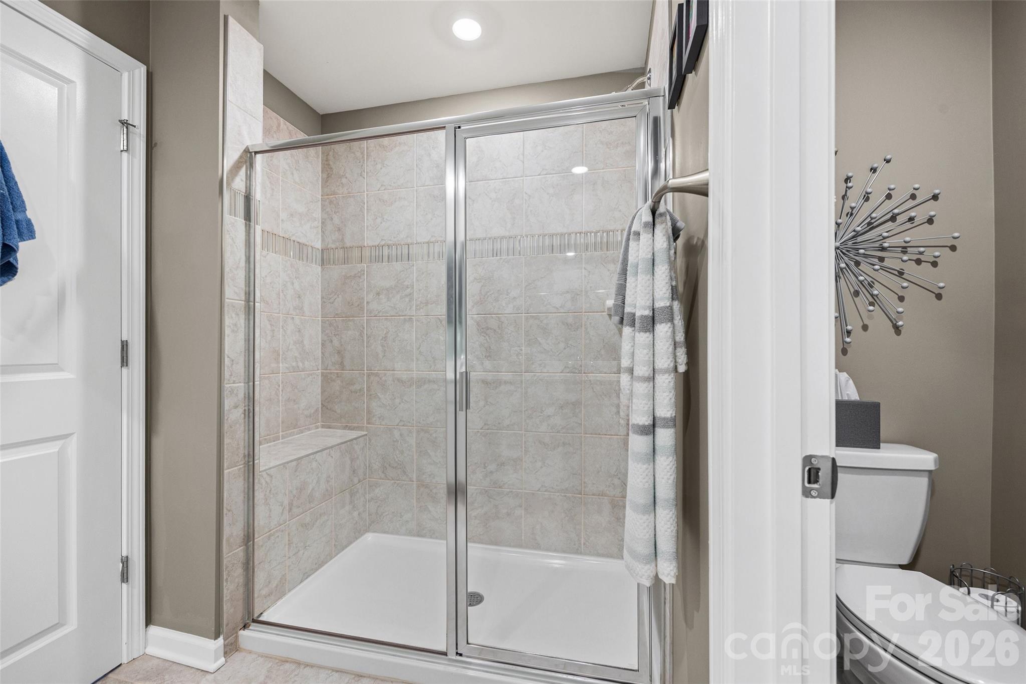 909 Cobbled Way Fort Mill, SC 29715 - Photo 22 of 31 a bathroom with a glass shower door