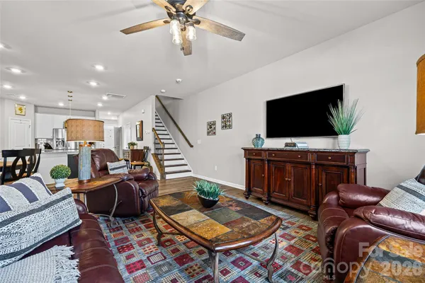 a living room with furniture a flat screen tv and a table