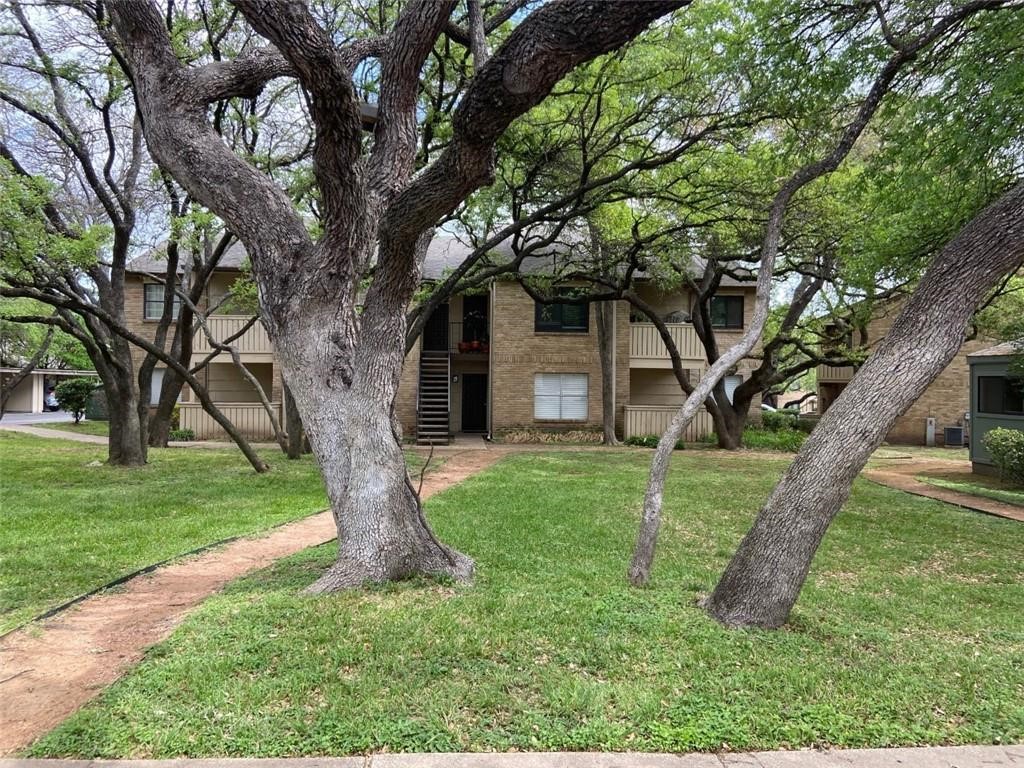 a view of a house with a tree and a backyard