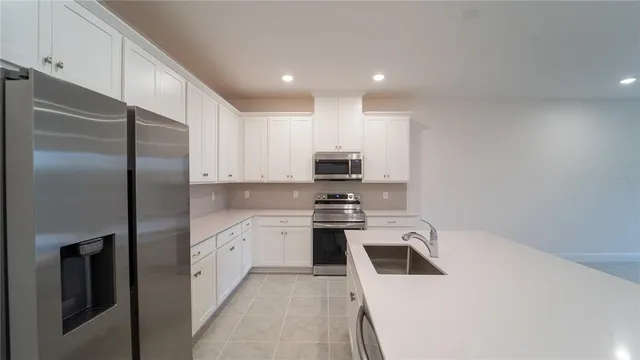 a kitchen with stainless steel appliances a refrigerator sink and stove