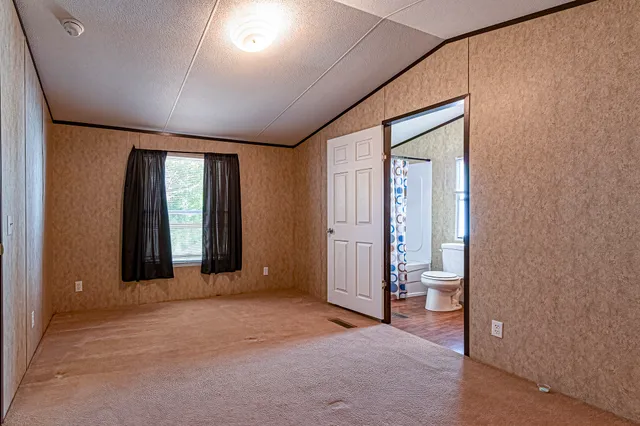 an empty room with closet and windows