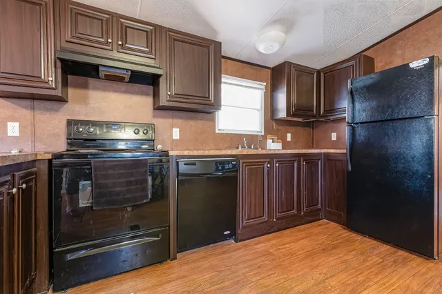 a kitchen with stainless steel appliances granite countertop a stove a sink dishwasher and a refrigerator