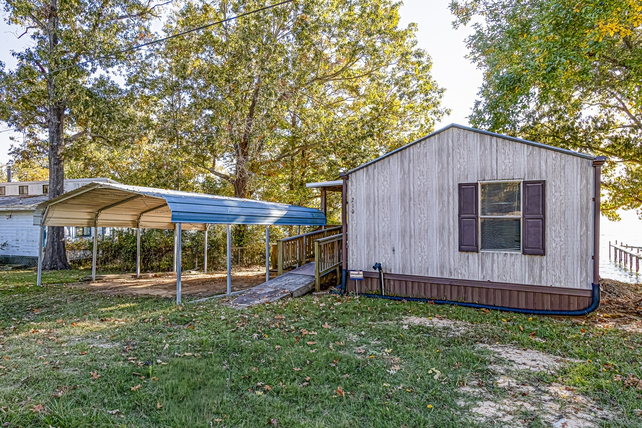 210 Rain Forest Road Onalaska, TX 77360 - Photo 2 of 26 a backyard of a house with wooden fence and a large tree