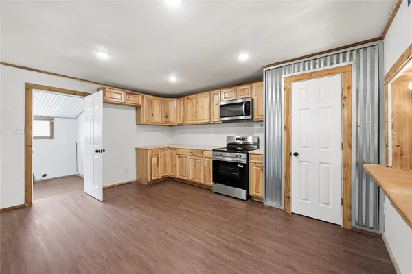 a kitchen with granite countertop a refrigerator and a stove top oven