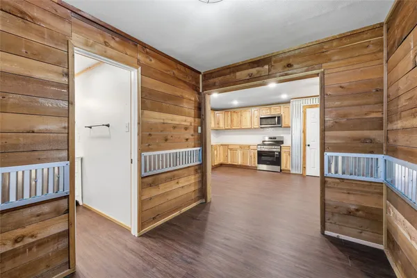 a view of a hallway with wooden floor and windows