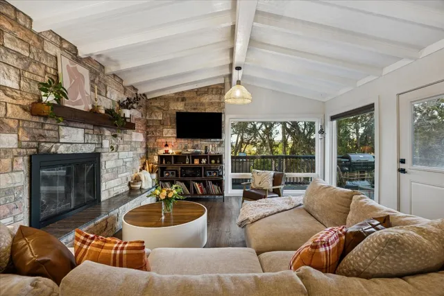a living room with furniture a fireplace and a flat screen tv