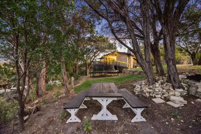 a view of a house with a big yard and large trees