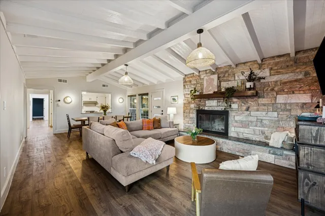 a living room with furniture a fireplace and a chandelier