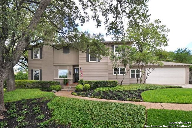 a front view of a house with a yard and potted plants