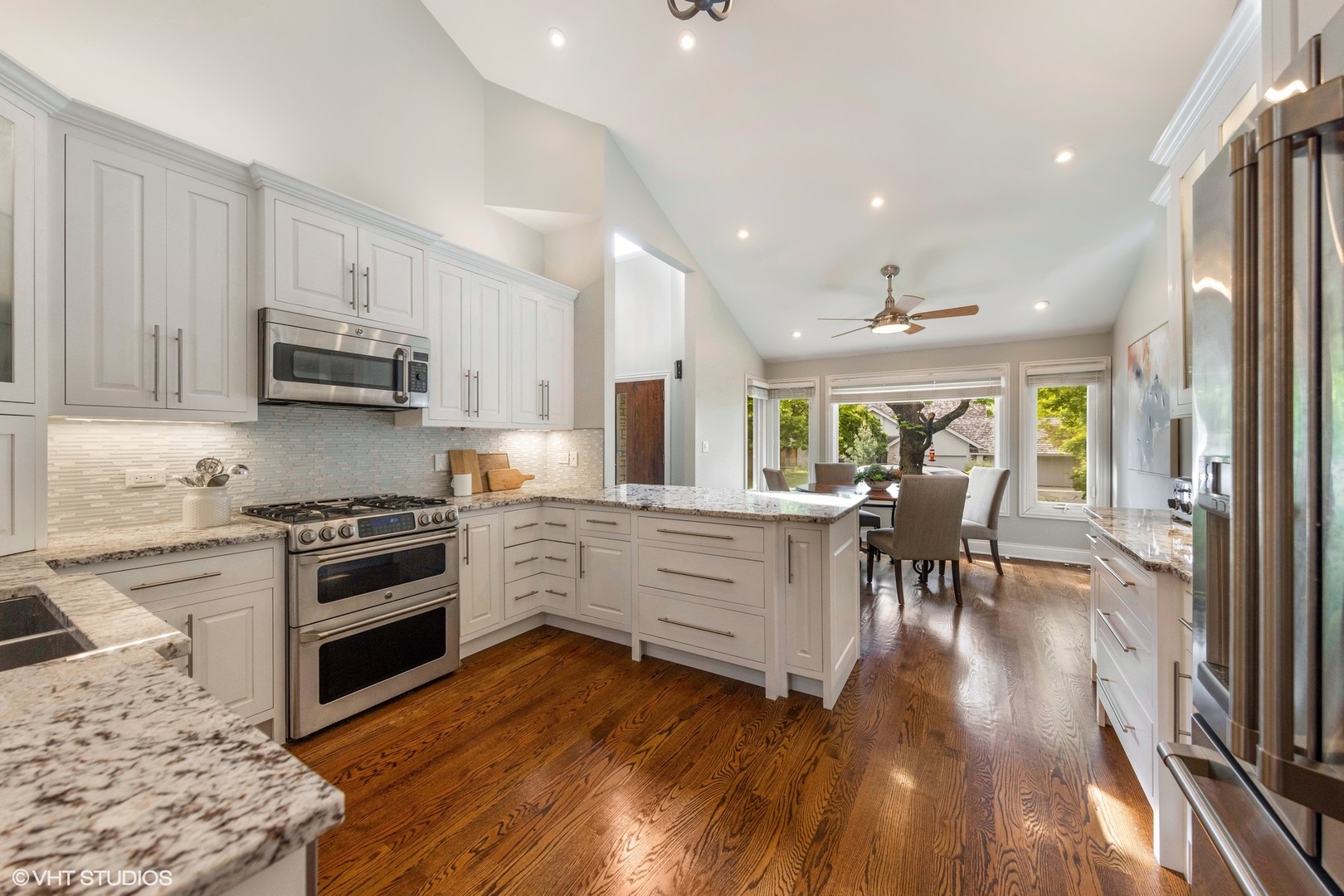 6 Bel Aire Court Burr Ridge, IL 60527 - Photo 7 of 37 a kitchen with stainless steel appliances granite countertop a stove top oven a sink a dining table and chairs with wooden floor