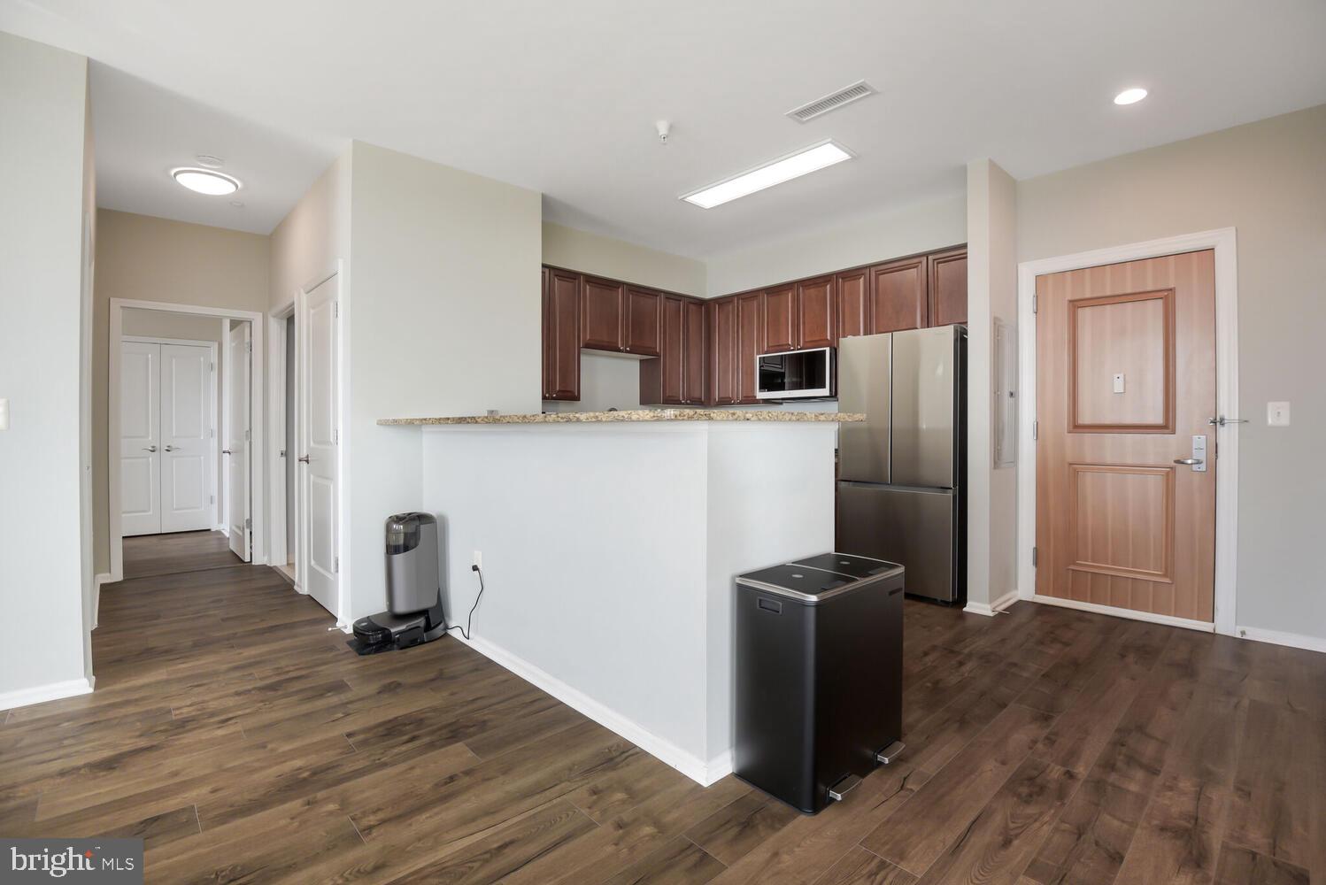 11700 Old Georgetown Road, Unit 1604 North Bethesda, MD 20852 - Photo 12 of 41 an empty room with wooden floor and a refrigerator