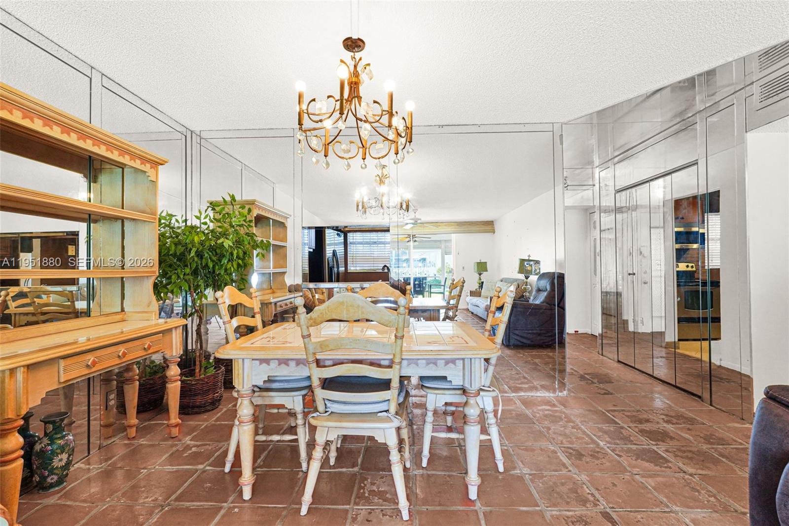 314 Southeast 10th Street, Unit 103 Dania Beach, FL 33004 - Photo 35 of 76 a view of a dining room and livingroom with furniture a chandelier and kitchen view