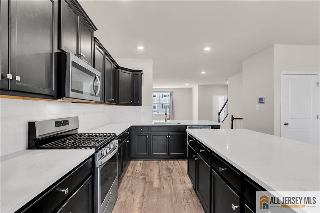 504 East International Road, Unit 504 Monroe Township, NJ 08831 - Photo 12 of 29 a kitchen with a stove sink and cabinets