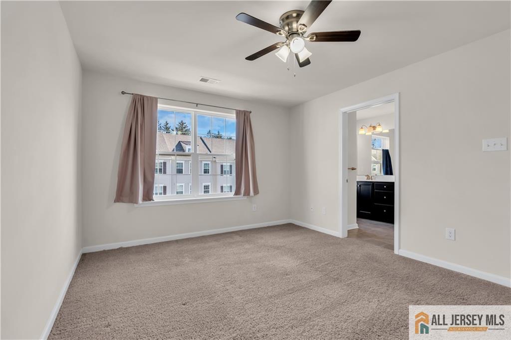 504 East International Road, Unit 504 Monroe Township, NJ 08831 - Photo 14 of 29 an empty room with fan and windows