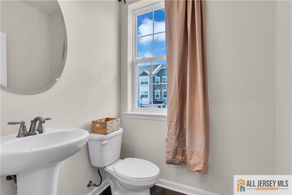 504 East International Road, Unit 504 Monroe Township, NJ 08831 - Photo 4 of 29 a white toilet sitting next to a bathroom sink