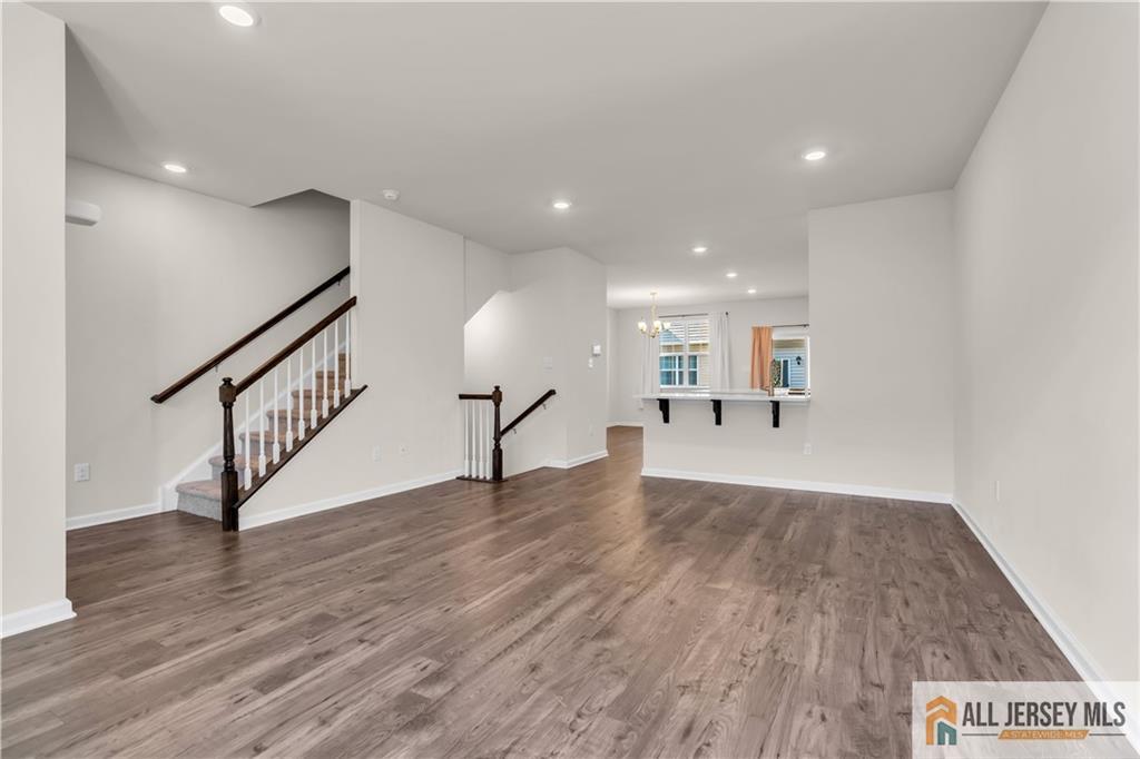 504 East International Road, Unit 504 Monroe Township, NJ 08831 - Photo 9 of 29 a view of a hallway with wooden floor and a chandelier