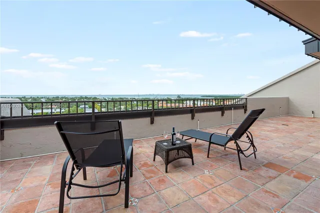 a roof deck with table and chairs