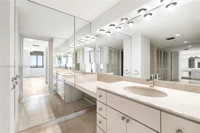 a spacious bathroom with a granite countertop sink a mirror and a shower