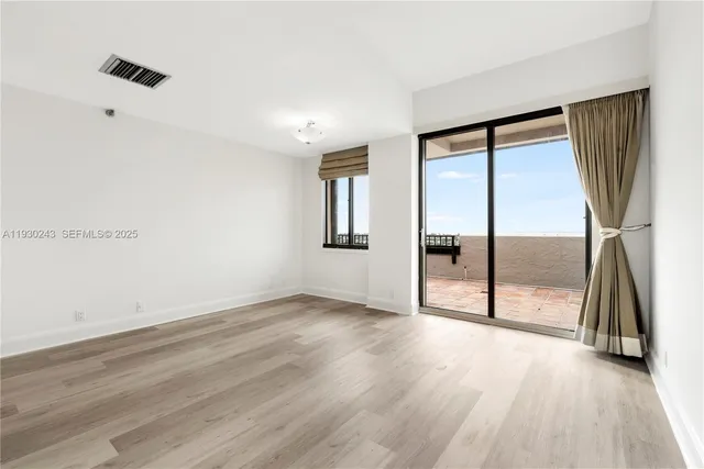 an empty room with wooden floor and a fireplace
