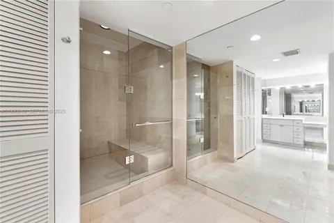 a bathroom with a glass shower door and a glass door shower