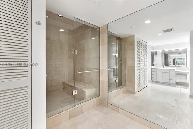 a bathroom with a glass shower door and a glass door shower