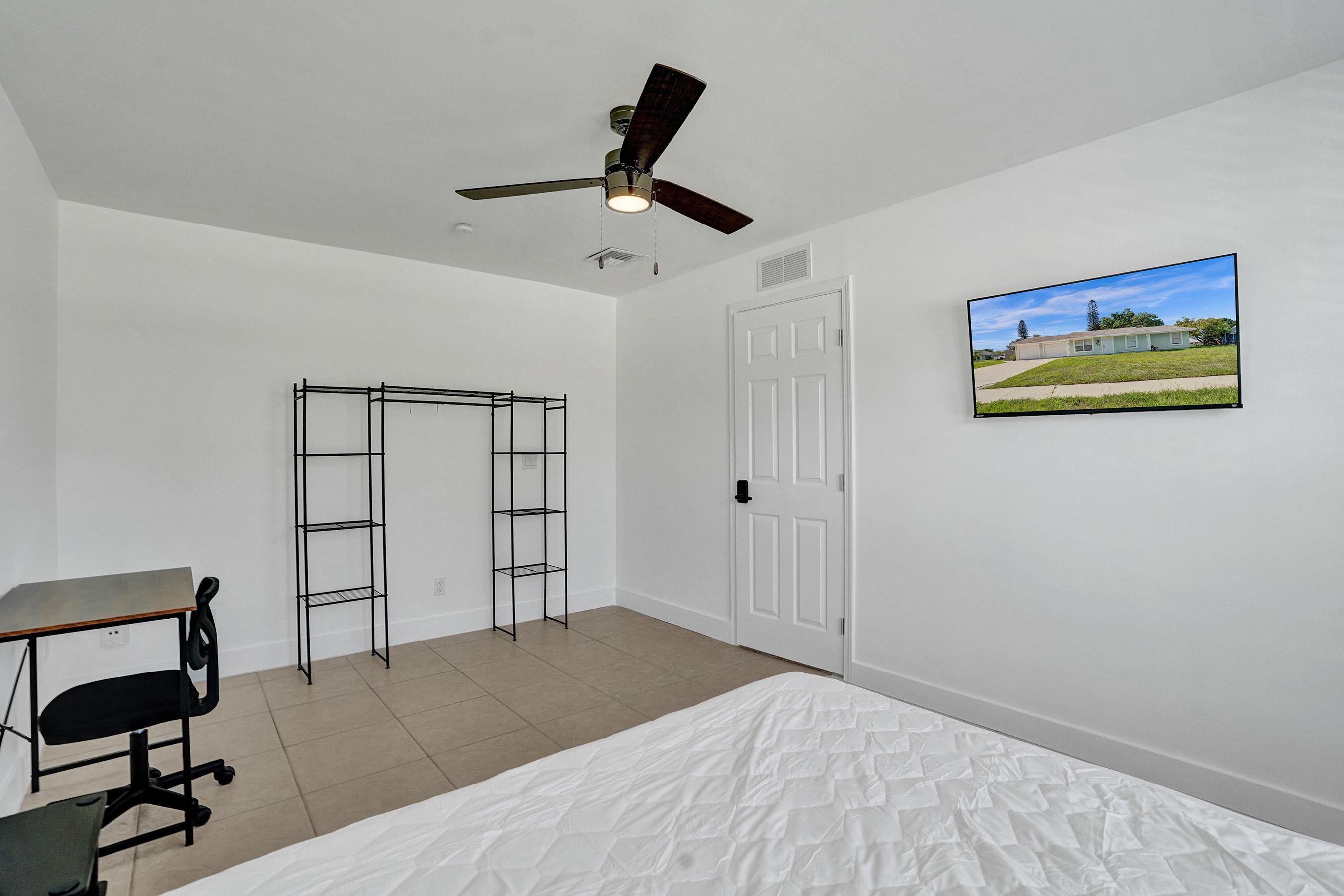 1075 West 30th Street Riviera Beach, FL 33404 - Photo 19 of 66 a bedroom with a bed and a bookshelf