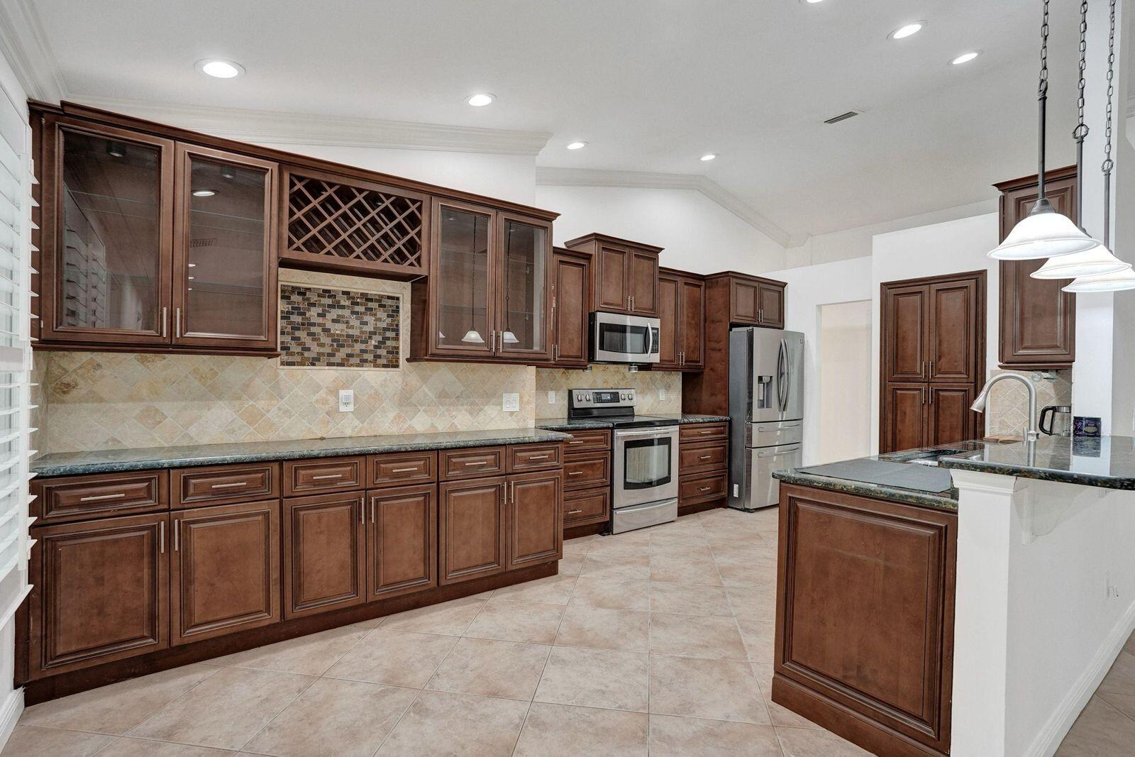 1075 West 30th Street Riviera Beach, FL 33404 - Photo 34 of 66 a kitchen with stainless steel appliances granite countertop a sink and cabinets
