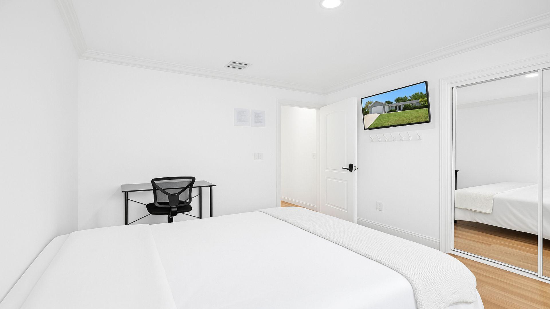 1075 West 30th Street Riviera Beach, FL 33404 - Photo 38 of 66 a bedroom with a bed and a chair