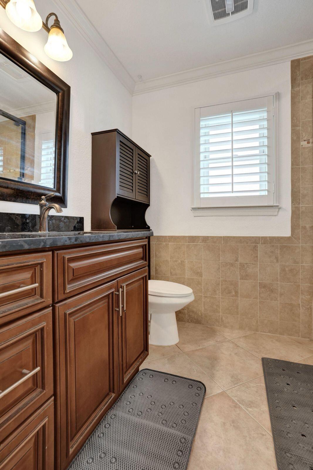 1075 West 30th Street Riviera Beach, FL 33404 - Photo 47 of 66 a bathroom with a toilet a sink and mirror