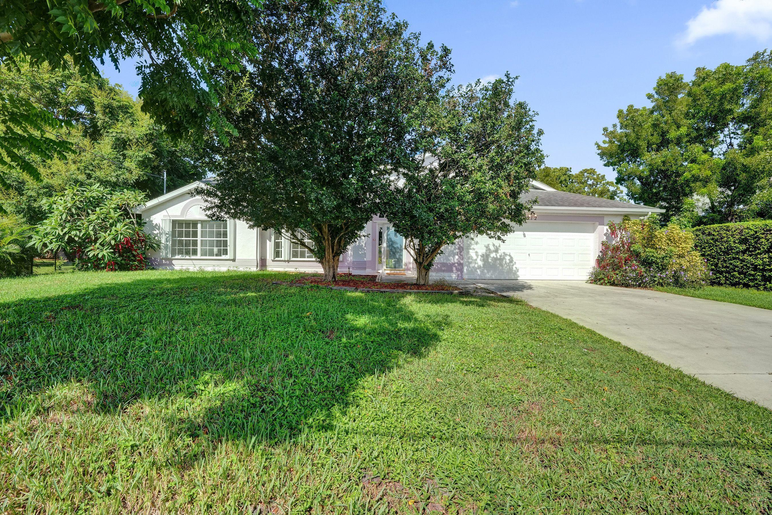 1075 West 30th Street Riviera Beach, FL 33404 - Photo 48 of 66 a front view of a house with a yard and trees