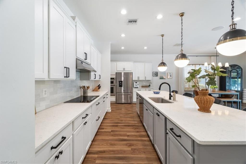 3524 Pilot Circle Naples, FL 34120 - Photo 9 of 30 a large kitchen with kitchen island a sink a counter space and stainless steel appliances