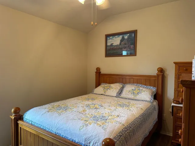 a bedroom with a bed and a painting on the wall