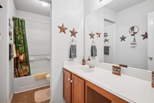 a bathroom with a sink vanity mirror and tub