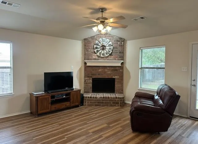 a living room with furniture a flat screen tv and a fireplace
