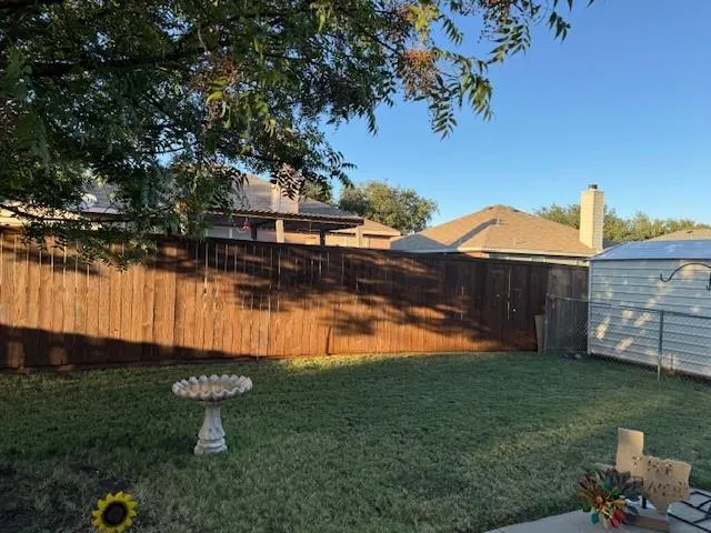 a view of a backyard with plants and lake view
